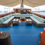 Luxury phinisi yacht deck with cushioned seating area and ocean view in Komodo